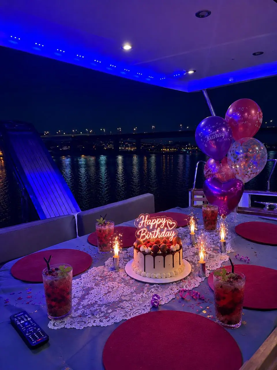 A birthday cake with sparklers on the deck table at night