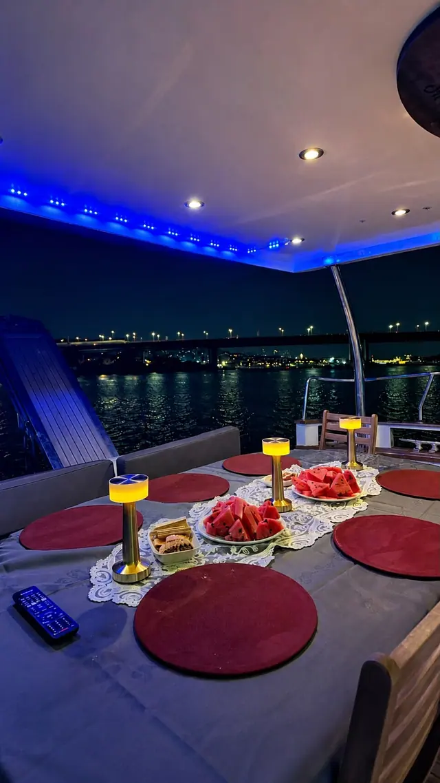 The deck of Hiluna at night with the lit bridge beyond
